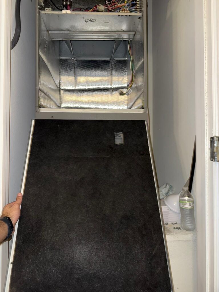 Technician holding a clean air filter in front of an A/C machine in Dade City FL